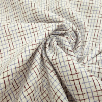 Белая рубашечная ткань с геометрическим риунком из голубых и коричневых нитей.