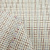 Белая рубашечная ткань с геометрическим риунком из голубых и коричневых нитей.